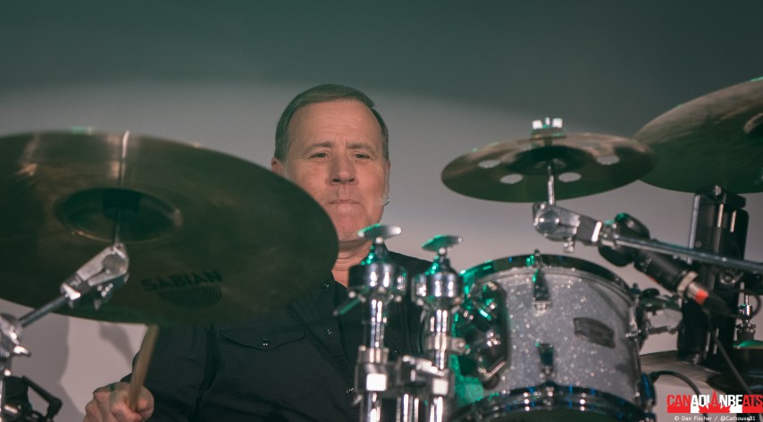 Rough Trade drummer playing a silver drum kit surrounded by cymbals during a concert at Maxwell's in Waterloo.